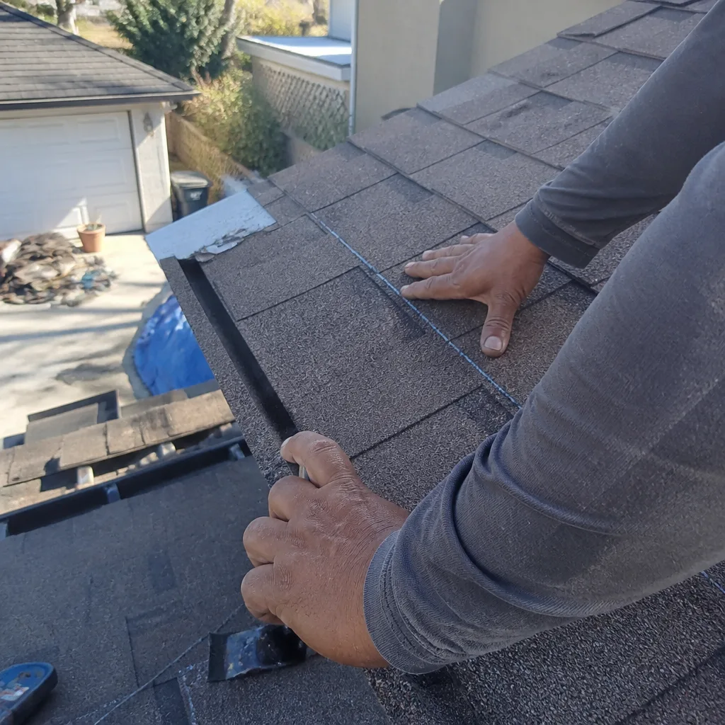 Professional roofer installing asphalt shingles on a residential house roof.