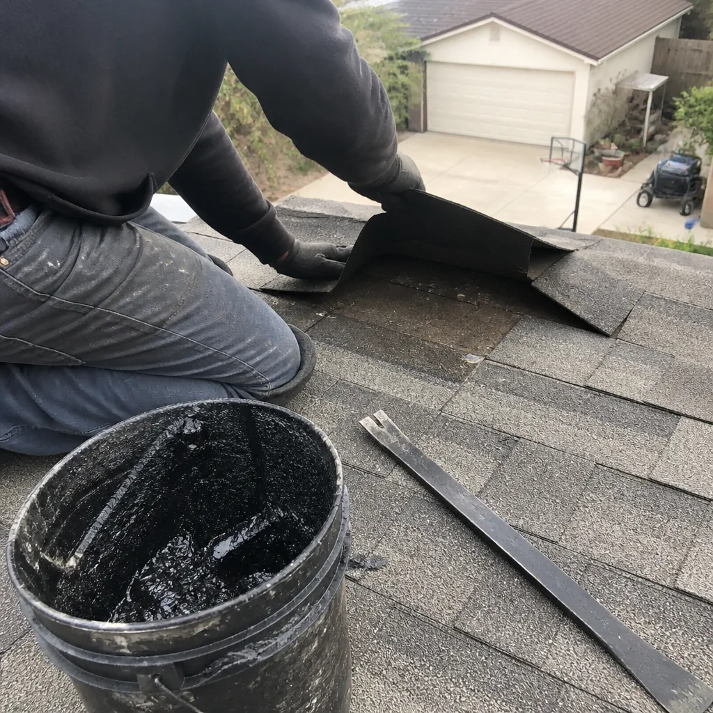 Professional roofer applying sealant to repair damaged shingles on a residential roof